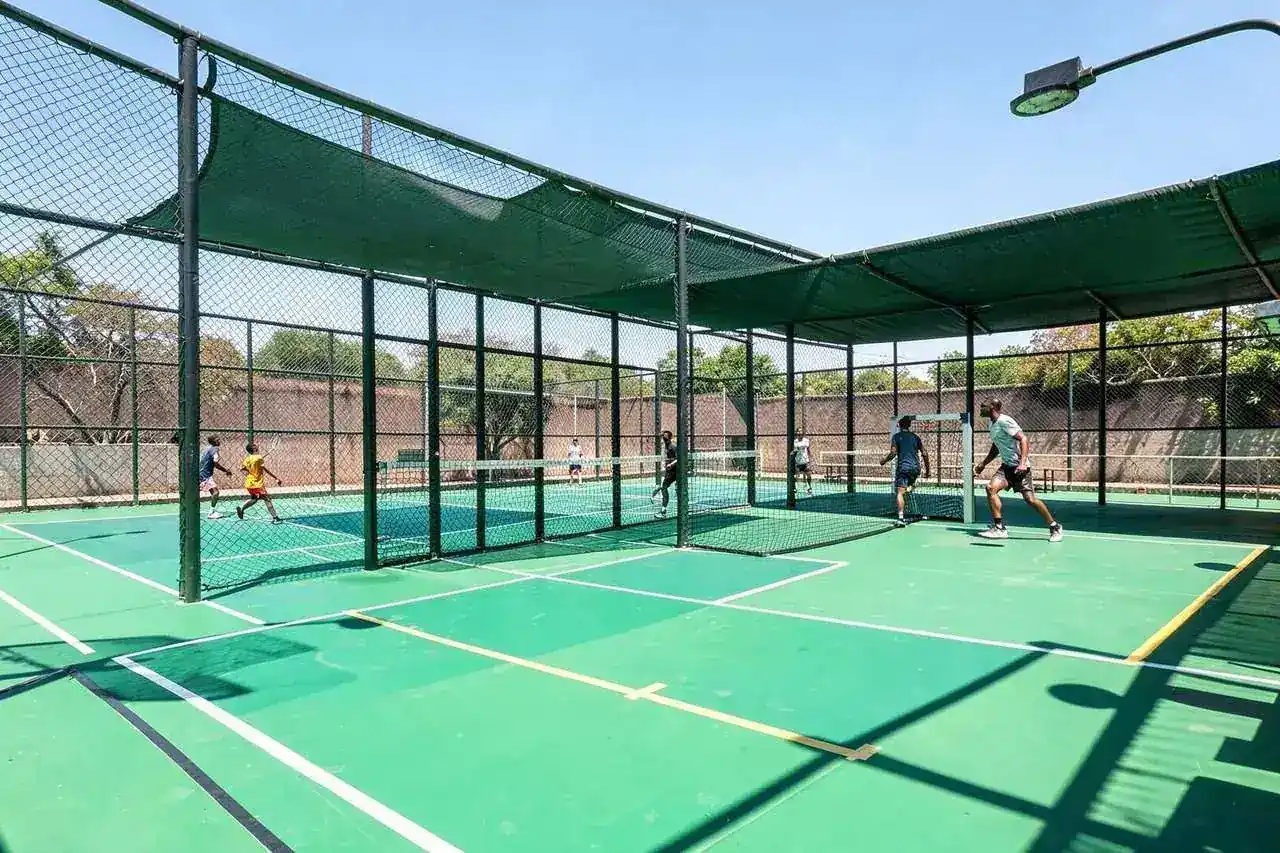 Floodlit padel and basketball court complex with shade netting